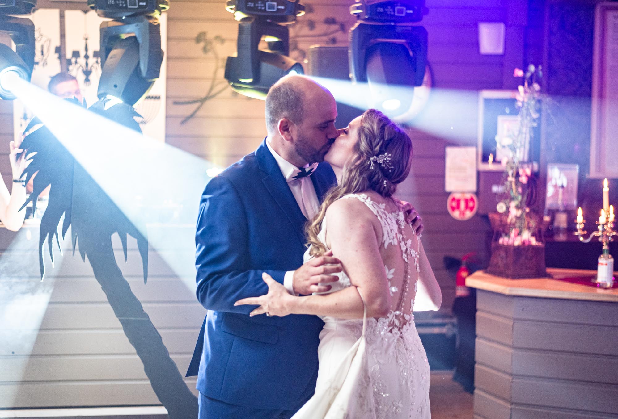 Danse des nouveaux époux qui s'embrassent sous les projecteurs pendant un mariage dans le Val d'Oise en région Île-de-France